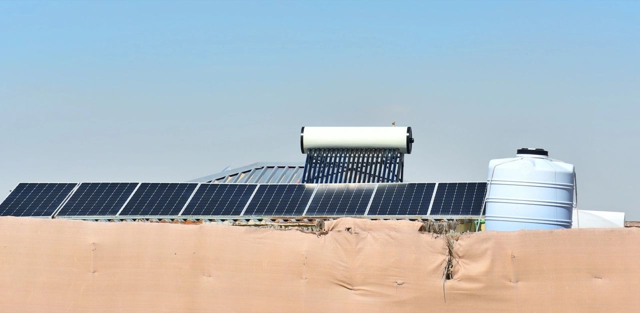 Solar panels and a rooftop tank suggest resilience, but this photograph cannot show whether the building has backup power or safe stored water. Illustrative stock image, not an ArchDaily project. Image-Source / Envato (spencerpa440).