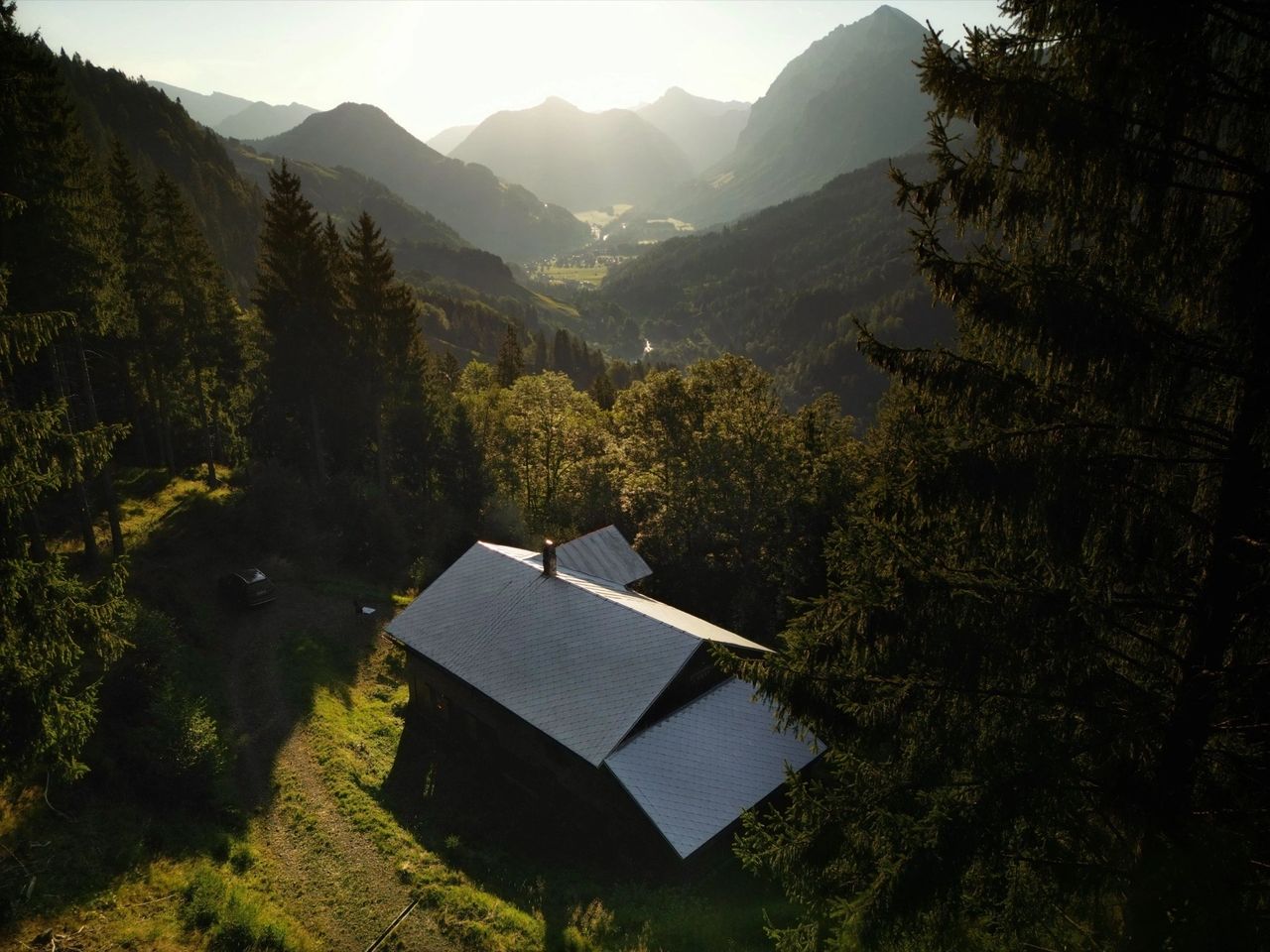 Remote cabin surrounded by forest in a mountain valley, illustrating an isolated refuge property